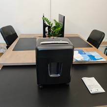 Ein schwarzer Aktenvernichter von Amazon Basics auf einem schwarzen Tisch.