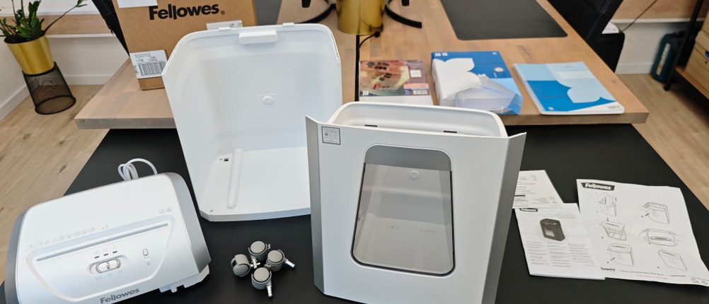 Die Einzelteile eines Fellowes Powershred liegen auf einem Schreibtisch.
