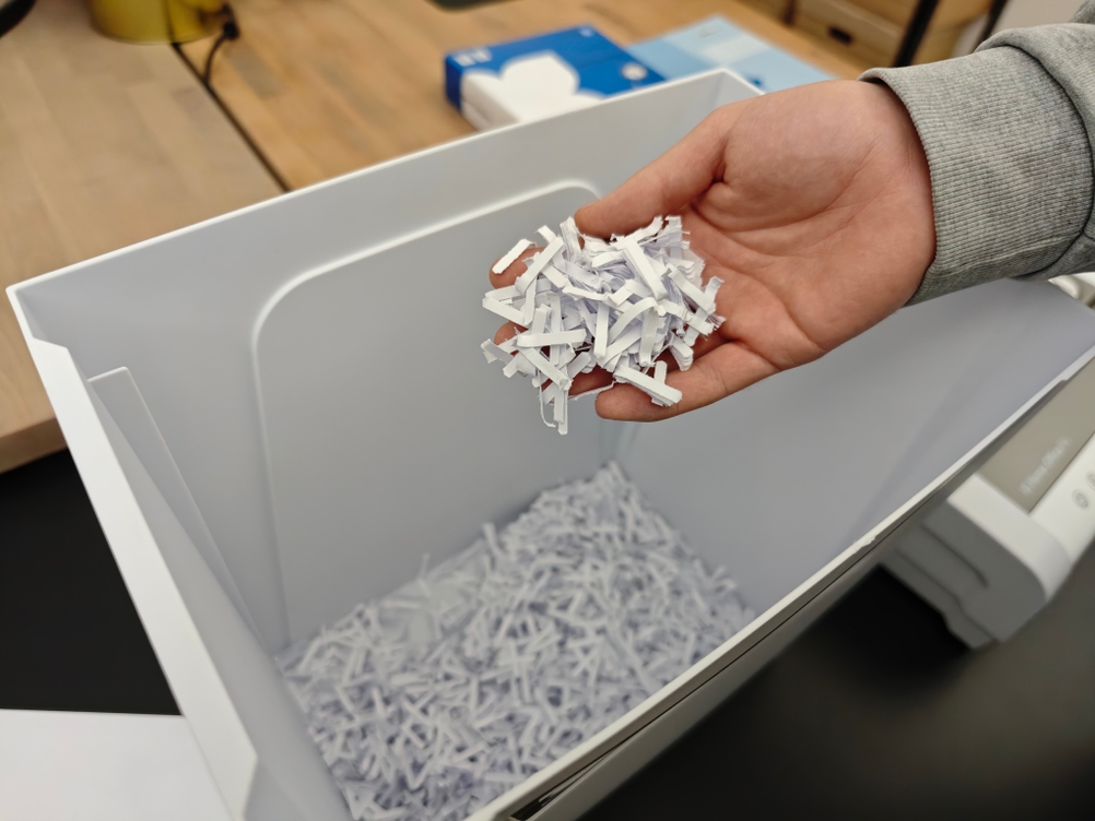 Eine Person hält Schnipsel eines Aktenvernichters in der Hand.