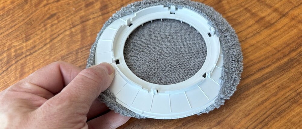 Eine Hand befestigt ein Pad des Alfabot X8 an der dafür vorgesehenen Halterung