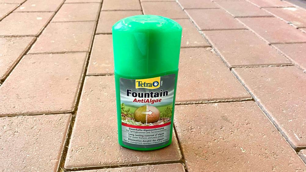 Algenentferner getestet: Eine Flasche mit Fokus auf den Deckel auf einer Steinfläche stehend.