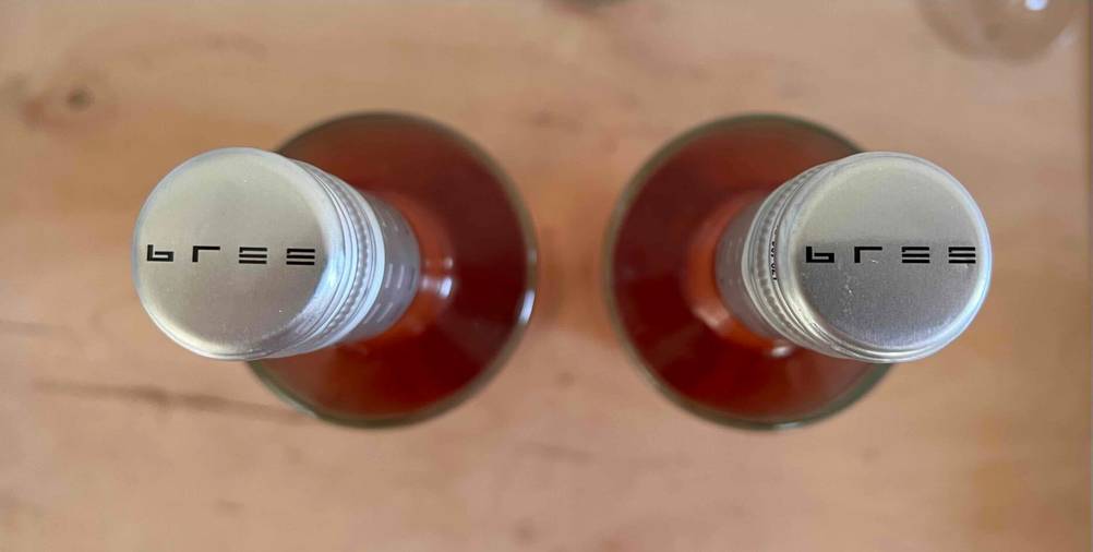 Alkoholfreier Wein im Test: Zwei Flaschen von oben auf einer Fläche, Nahaufnahme der Verschlusskappen.