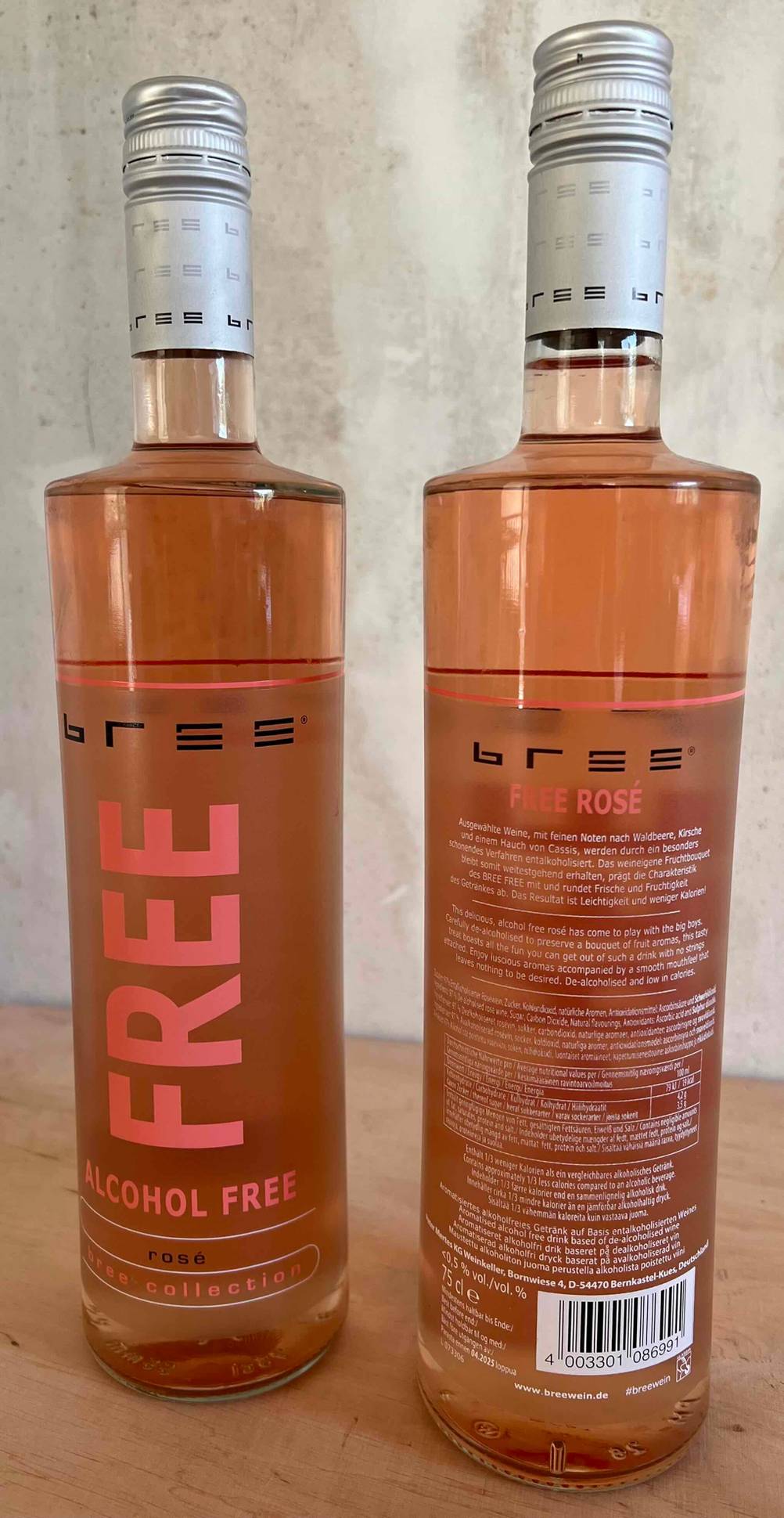 Alkoholfreier Wein getestet: Zwei Flaschen auf einer Holzfläche, eine von vorne eine von hinten.