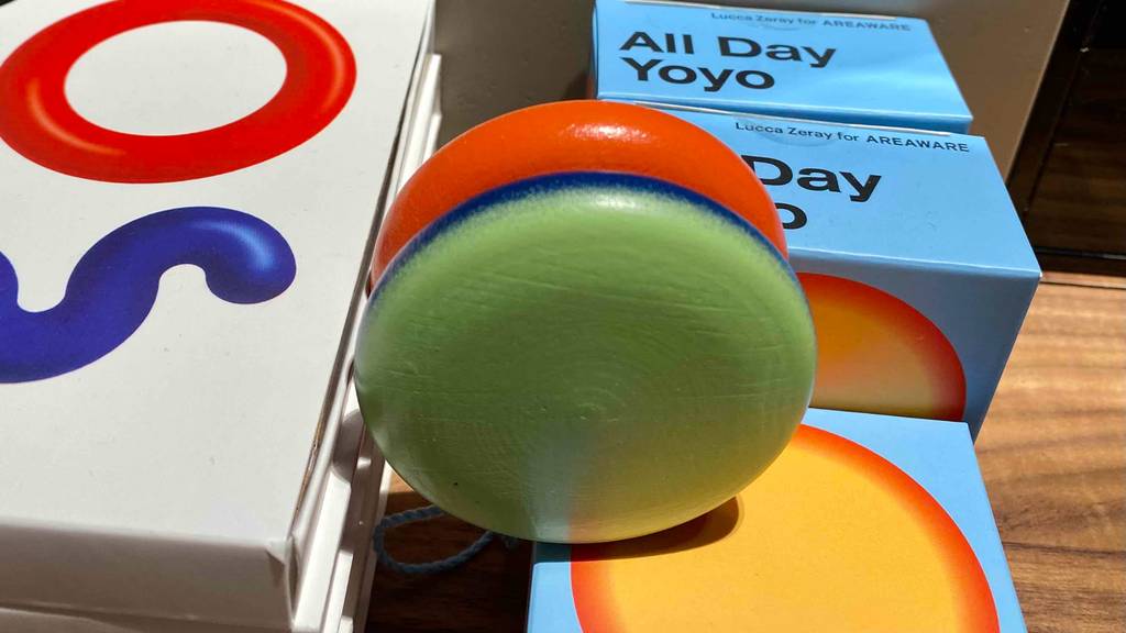 Auf Spielzeugverpackungen steht ein getestetes Jo-Jo von All Day in der Farbe Grün und Orange.