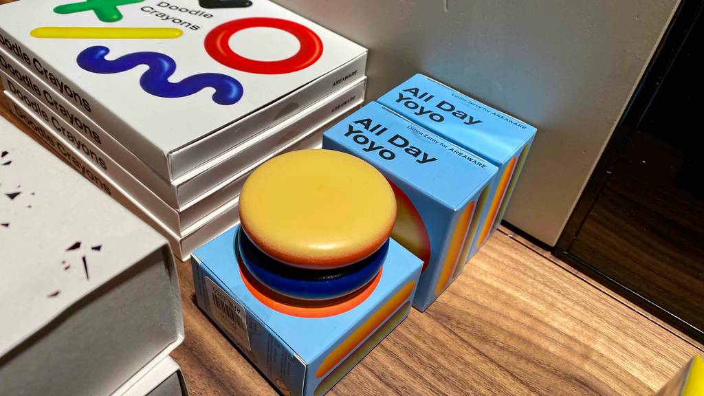 Auf einem Regal befinden sich neben Spielzeugverpackungen getestete Jo-Jos von All Day in bunten Farben, gelb und blau.