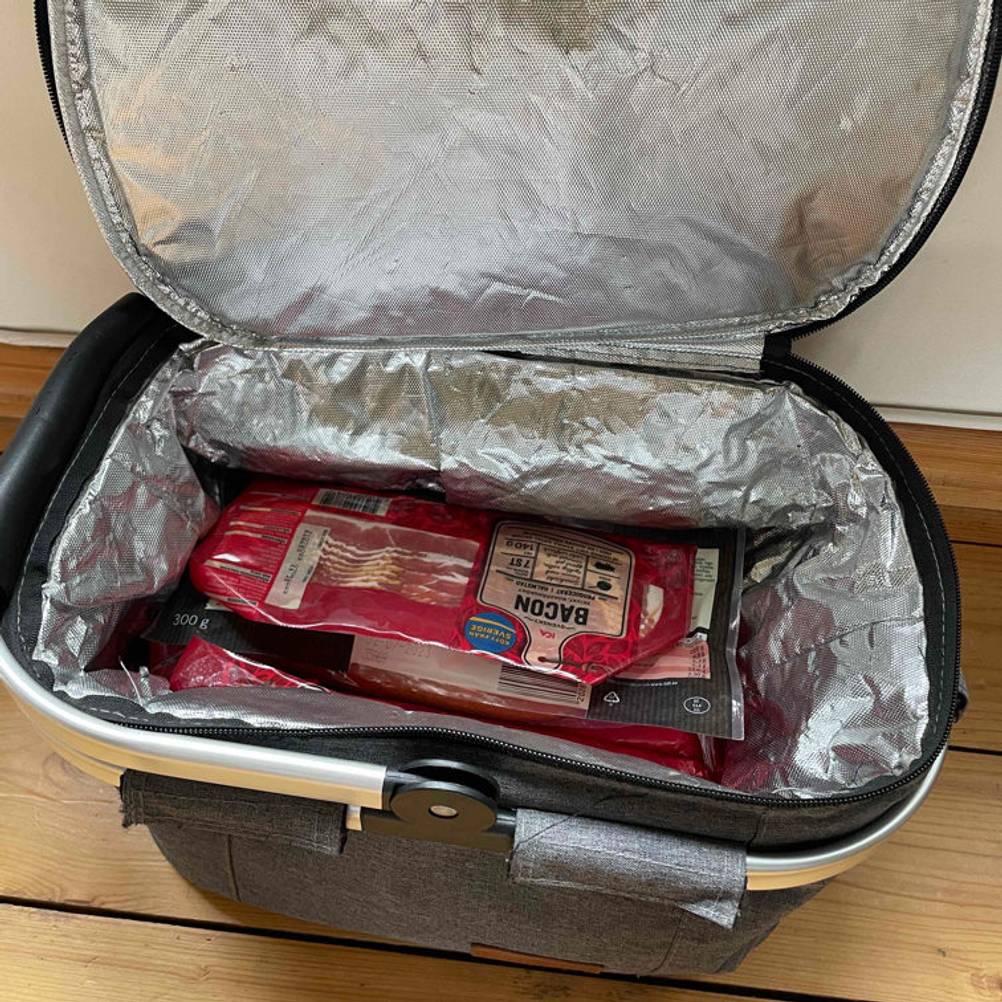 Geöffneter Allcamp Einkaufskorb ist gefüllt mit Wurstwaren.