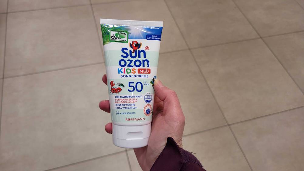 Eine Hand hält eine Tube der Allergie-Sonnencreme im Test.