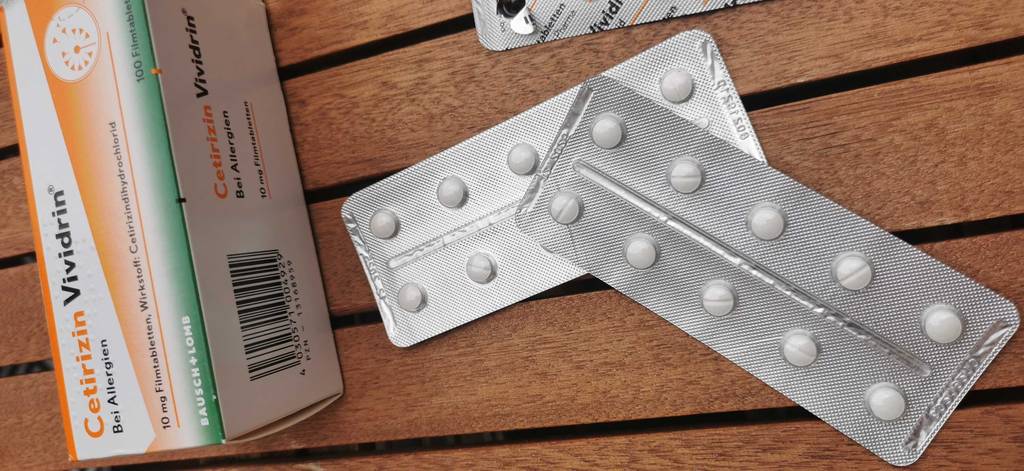 allergietabletten mit Verpackung auf Holzoberfläche