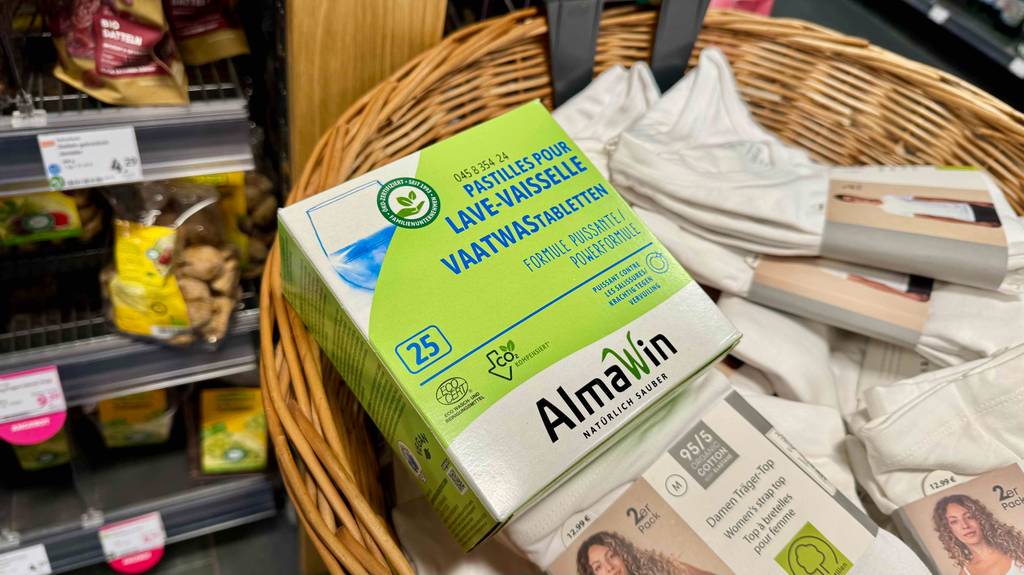 Öko-Spülmaschinentabs im Test befinden sich in der grünen Verpackung in einem Kob mit original verpackter Unterwäsche.