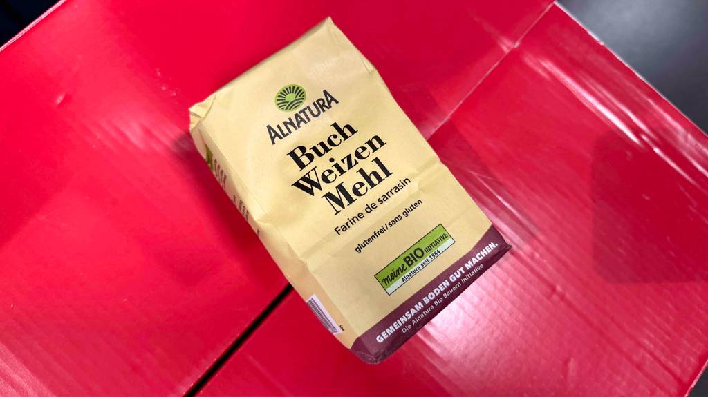 Eine Packung Buchweizenmehl liegt zum testen auf roten Kartons.