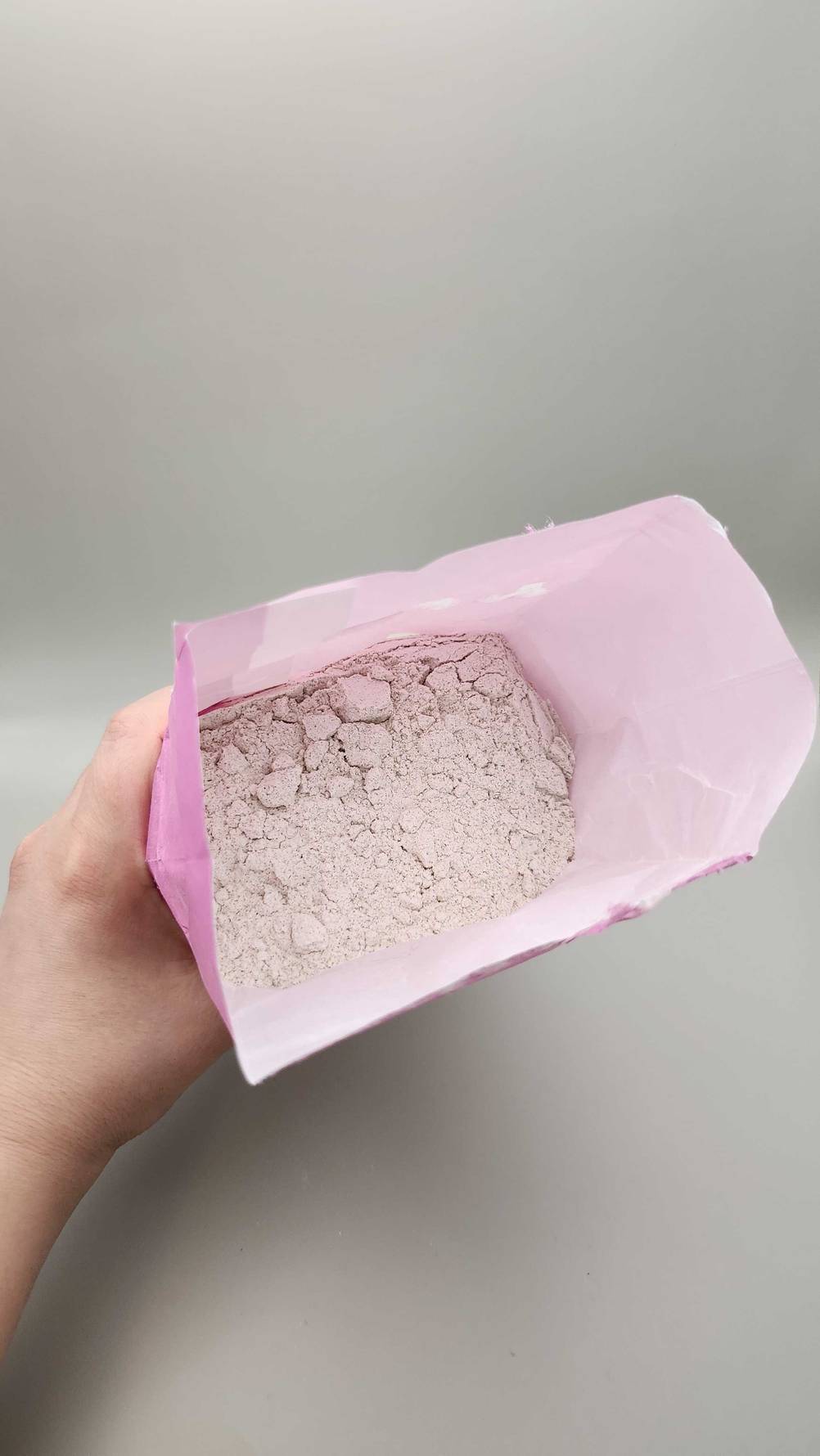 Im Test: Eine Hand hält eine geöffnete Packung mit Buchweizenmehl, Blick von oben.