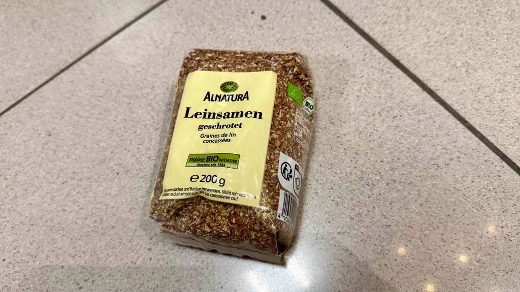 Geschroteter getesteter Leinsamen in der 200-g-Packung liegt auf dem Boden.