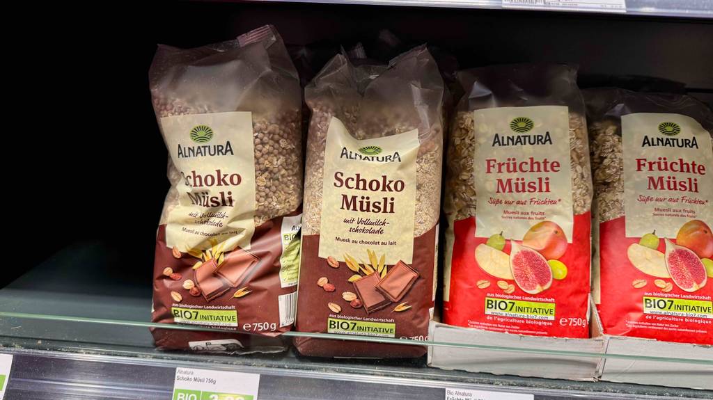 Schoko-Müsli-Test: Mehrere Packungen stehen in zwei Reihen neben Früchtemüsli in einem Regal.