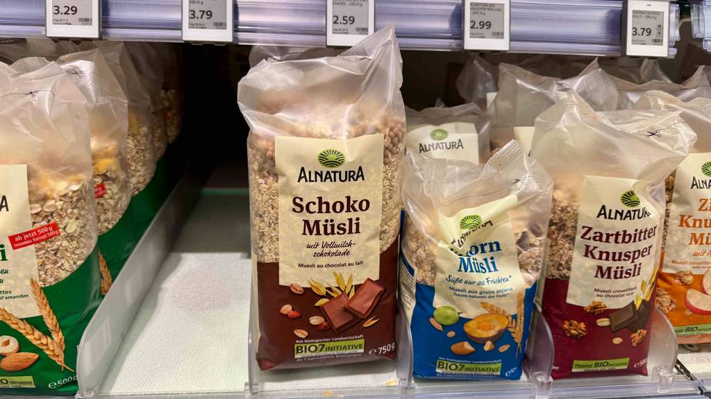 Schoko-Müsli im Test: Mehrere Packungen stehen zwischen anderen Müsli-Sorten in einem Regal.