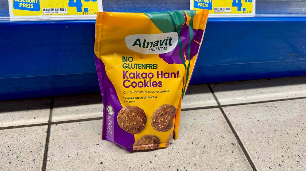Eine Packung glutenfreie Kekse steht zum testen vor einem Verkaufsregal auf dem Boden.