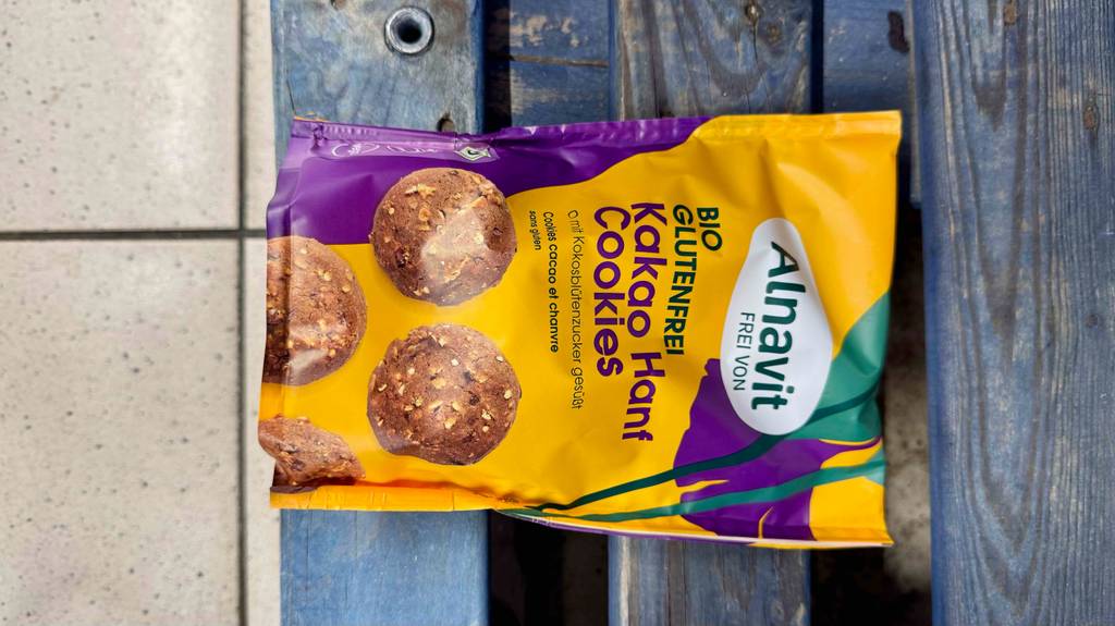 Glutenfreie Kekse getestet: Auf einer Packung, die quer auf blauen Holzlatten liegt, sind große Cookies abgebildet.