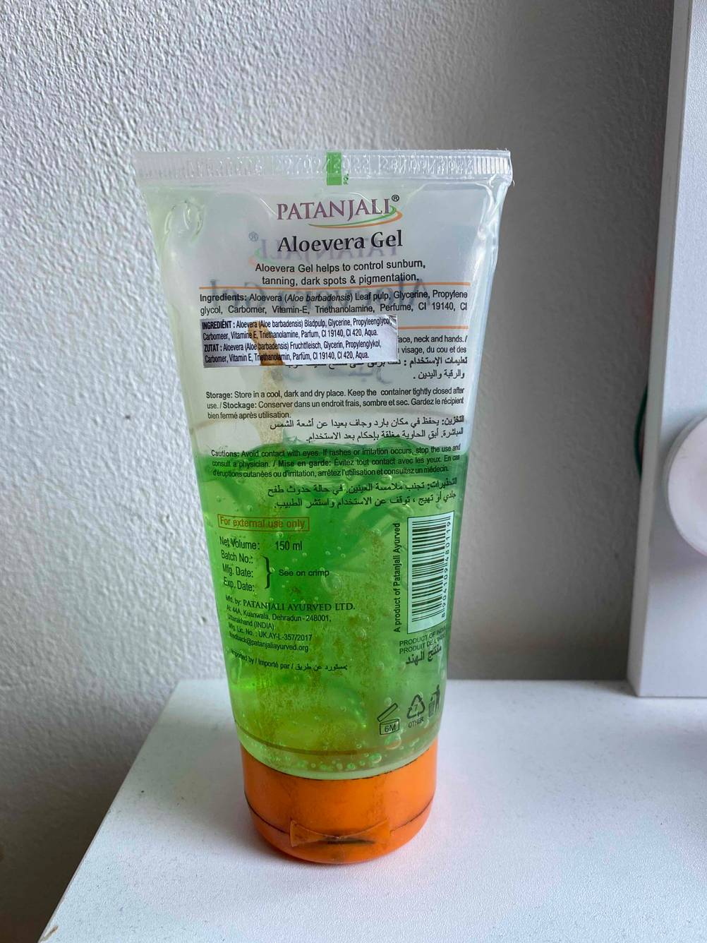 Rückseite einer Tube des getesteten Aloe Vera Gels auf einer hellen Fläche vor einer weißen Wand.