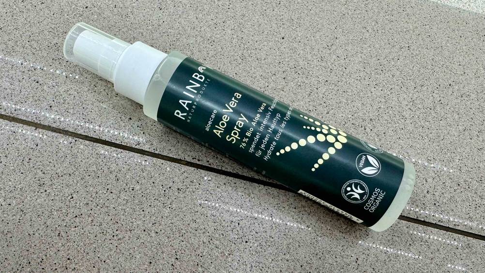 Ein Aloe-vera-Spray horizontal auf einem Fließenboden.