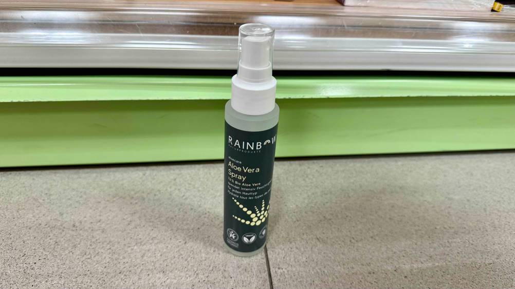 Auf einem beigen Boden steht eine Flasche des getesteten Aloe-vera-Sprays.