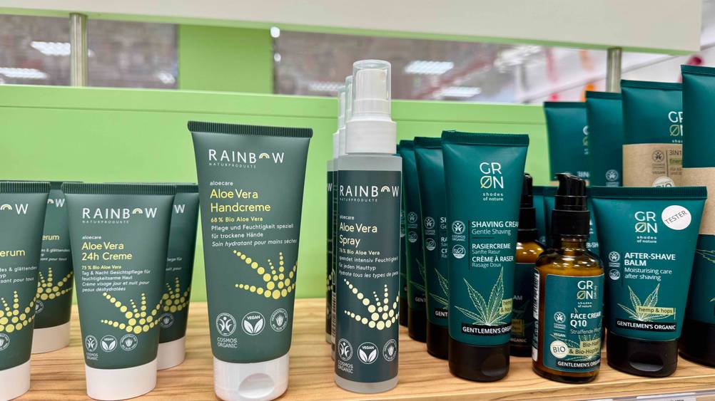Aloe-vera-Spray im Test: Mehrere Flaschen stehen in einem Verkaufsregal neben anderen Produkten.