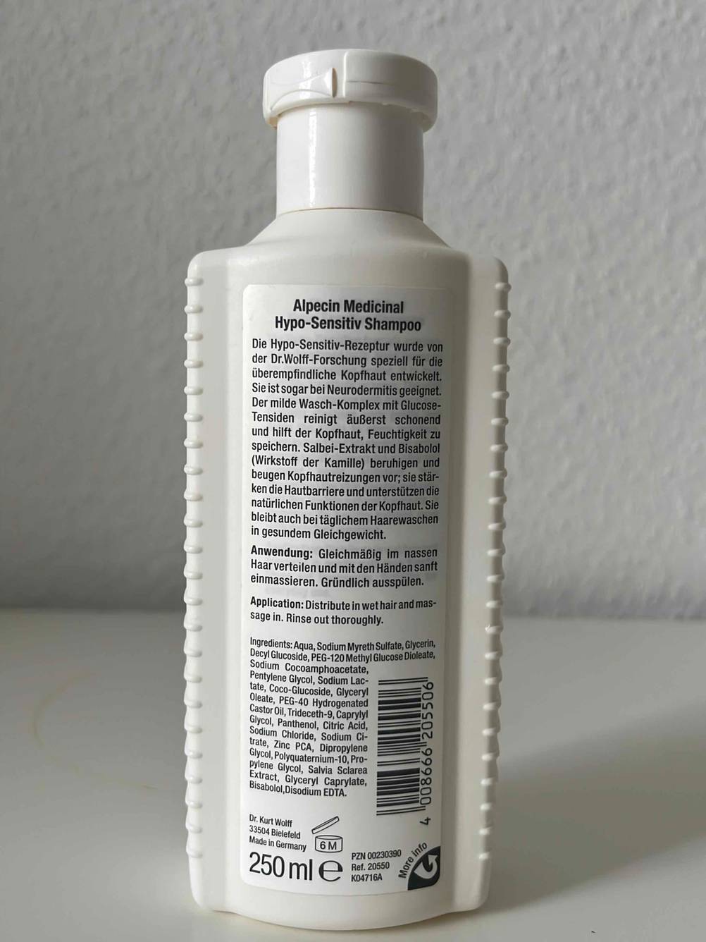 Haarwasser im Test: Gesamtansicht der 250-ml-Flasche der Marke Alpecin, mit Fokus auf das rückseitige Informations-Etikett zu Anwendung und Produkt.
