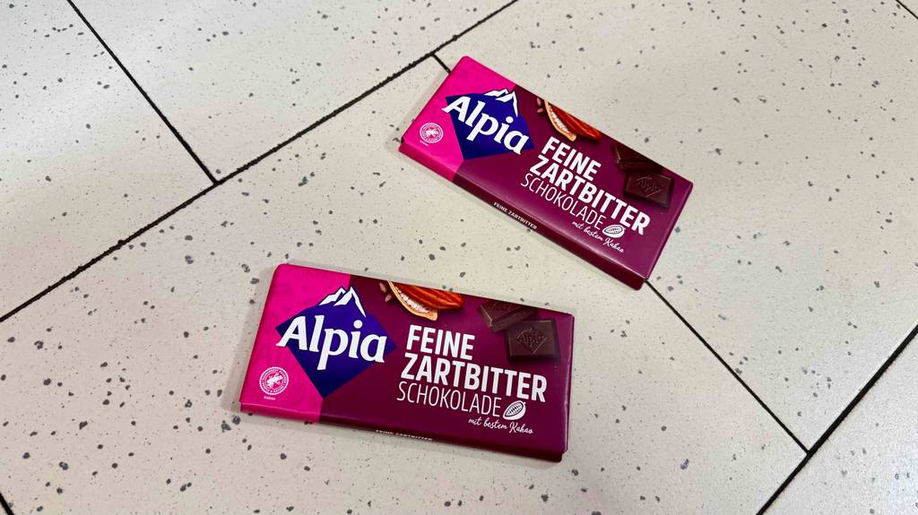 Im Test: Zwei Tafeln Alpia-Schokolade liegen auf einem Fliesenboden.