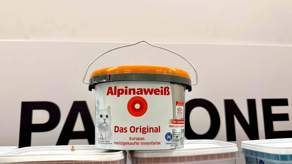 Die getestete Alpina-Farbe steht vor einer hellen Wand.