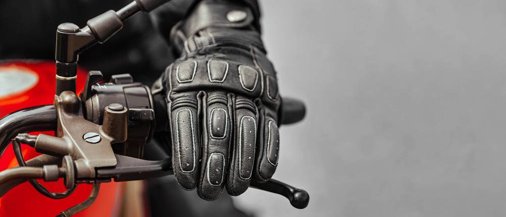 Alpinestars-Handschuhe im Test: Die Hand eines Motorradfahrers liegt auf dem Kupplungshebel eines Motorrads.