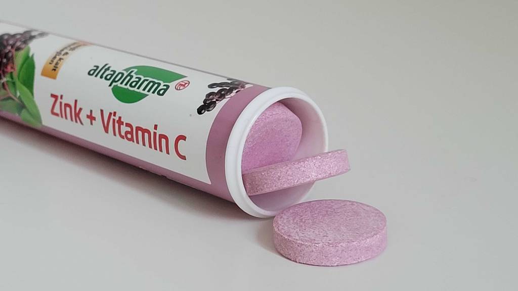 Aus einer geöffneten Dose getesteter Vitamin-C-+-Zink-Kapseln schauen einige Kapseln hervor.