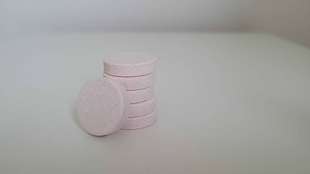 Getestete Multivitamin-Brausetabletten liegen gestapelt auf einer weißen Oberfläche.