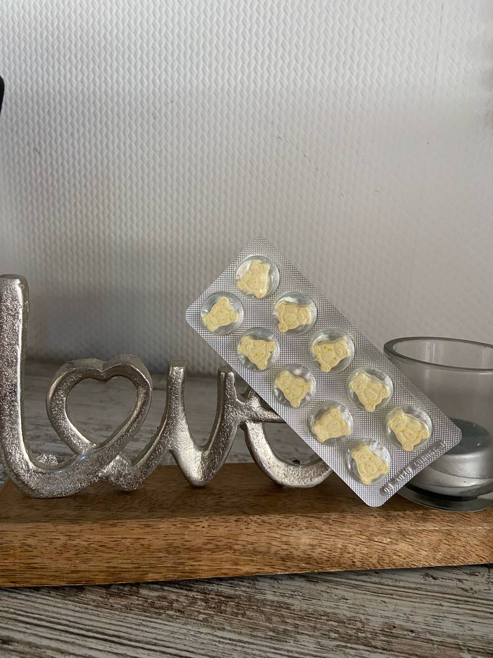 Im Test: Ein Blister Multivitaminpräparat lehnt an eine LOVE-Deko