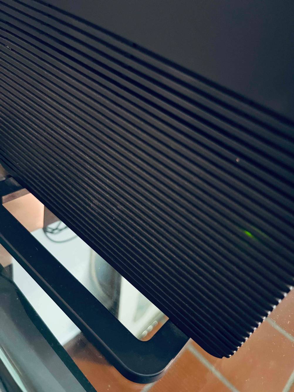Detailaufnahme des Lüfters und Teil des Standfußes eines schwarzen Glasfaser-Routers im Test.