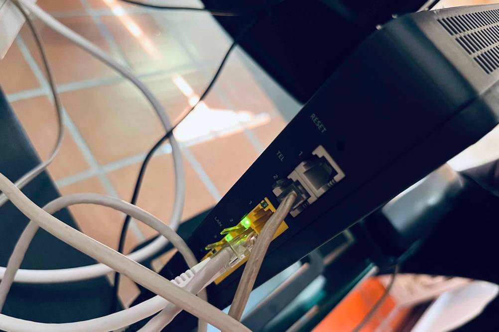Detailansicht der Verbindungs-Buchsen eines schwarzen Glasfaser-Routers im Test.