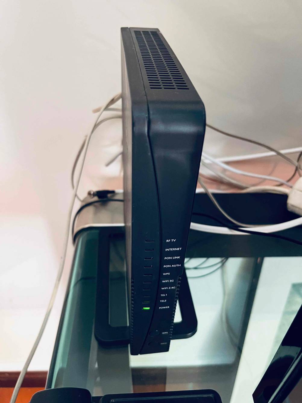 Ein schwarzer Glasfaser-Router im Test steht auf einem Glastisch.
