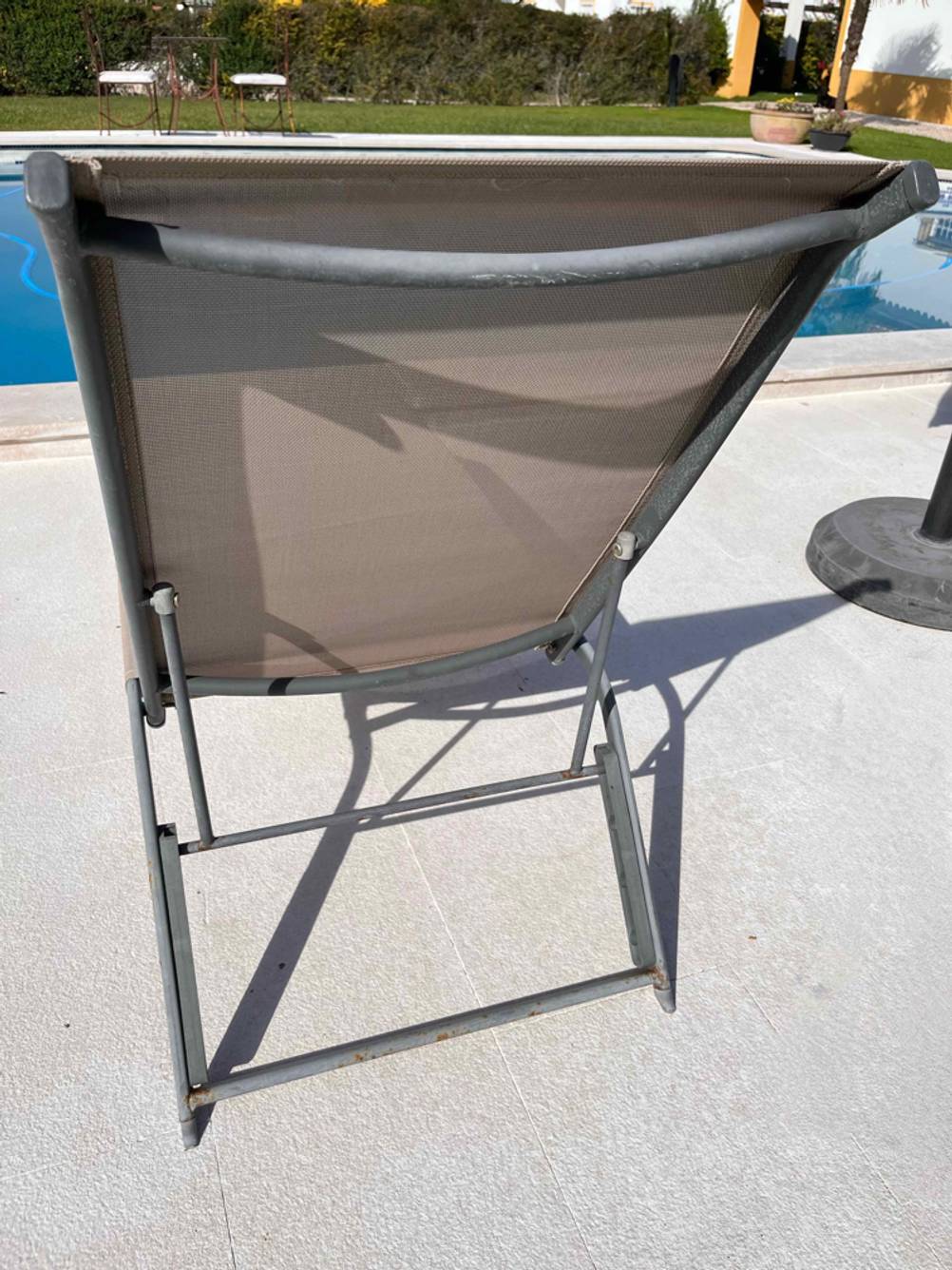 Rückwärtige Ansicht auf die Rückenlehne einer grauen, mit Stoff bespannten Aluminium-Sonnenliege im Test.