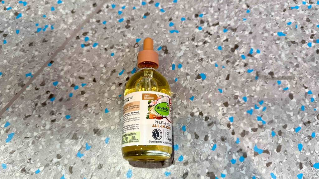 Eine Flasche getestete Alverde-Gesichtspflege liegt auf einem Boden.