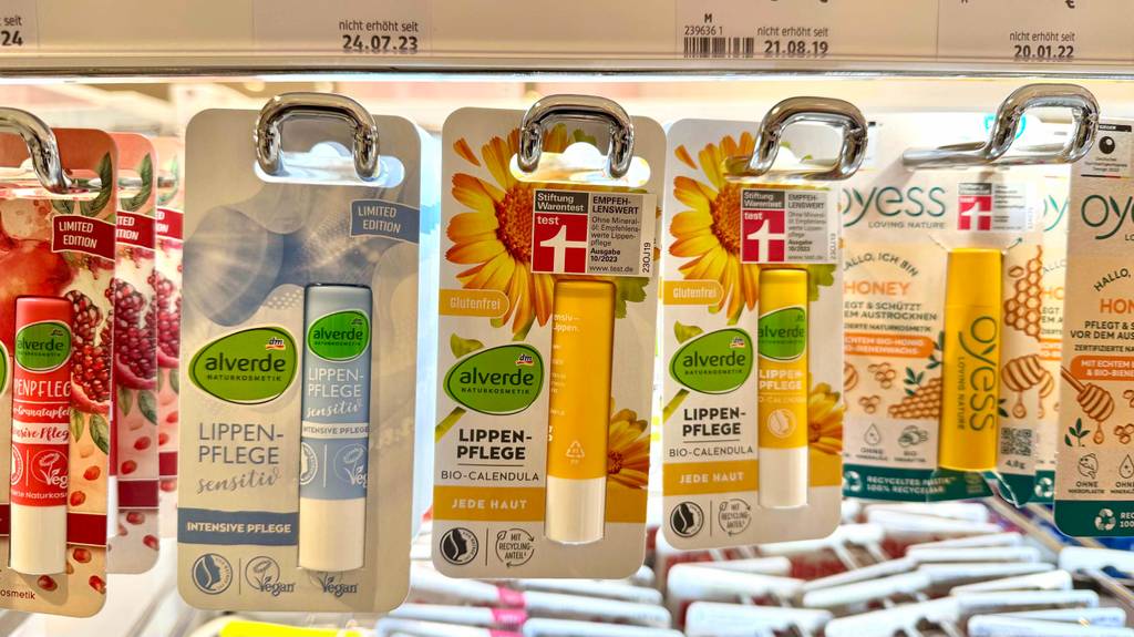 Getestet: Die Lippenpflege-Naturkosmetik in der Verpackung hängt neben weiteren Lippenpflegeprodukten an einem Verkaufsregal.