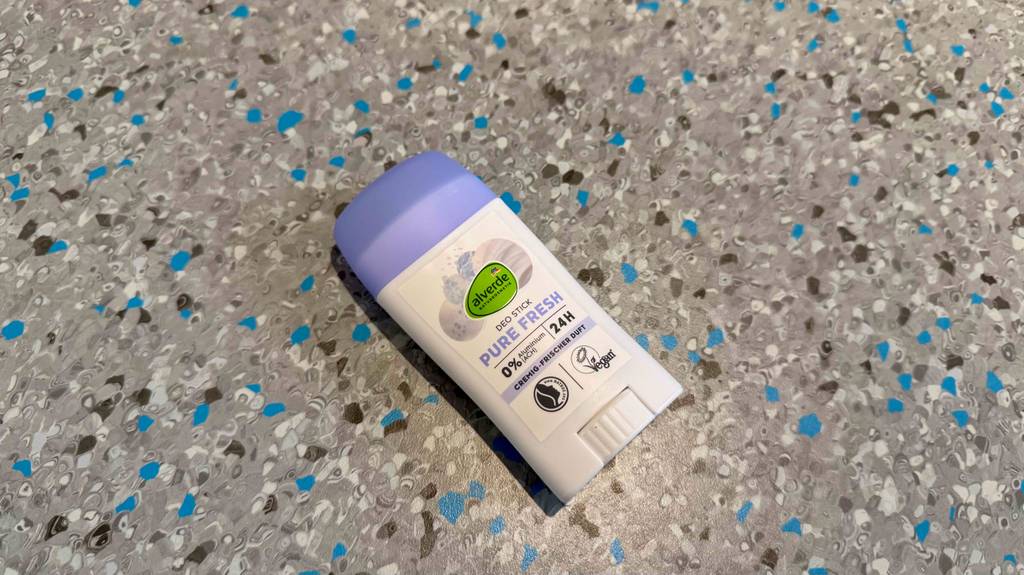 Ein getestetes Naturkosmetik-Deo liegt auf einem gesprenkelten Boden.