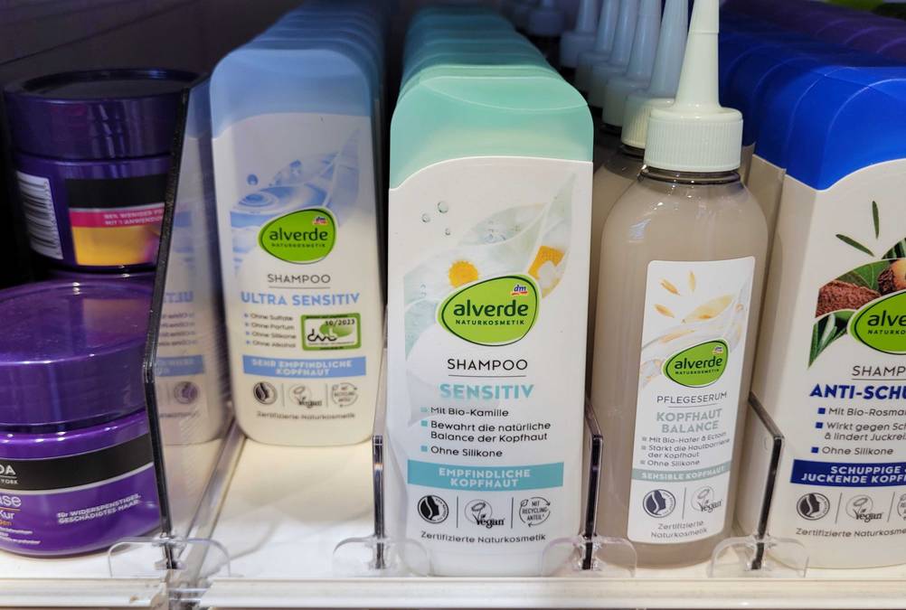 Mehrere Flaschen des getesteten alverde-Shampoos stehen neben anderen Produkten in einem Verkaufsregal.