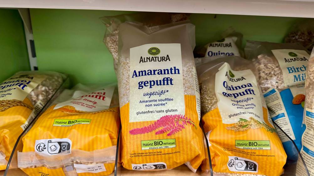 In einem Regal neben anderen Produkten befindet sich eine Packung des Amaranth gepufft.