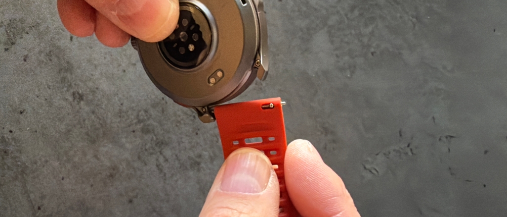 Eine Hand befestigt ein Armband an der Amazfit Balance 2