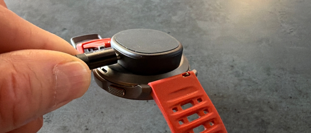 Eine Hand legt das Ladegerät auf die Amazfit Balance 2