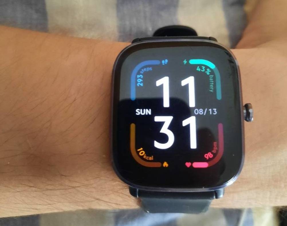 Amazfit GTS 2 Mini EKG-Uhr getestet an einem Handgelenk. Auf der Anzeige sind Funktionsangaben und Uhrzeit ersichtlich.
