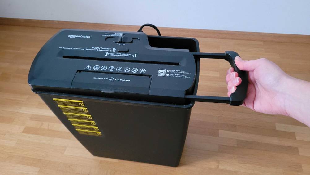 Im Test: Eine Hand hält den Aktenvernichter an einem Henkel fest.