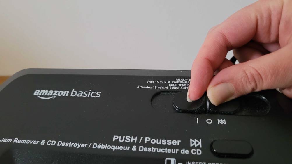 Nahaufnahme einer Hand die den An-Aus-Schalter des Aktenvernichters im Test betätigt.