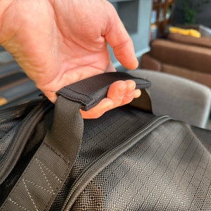 Eine Hand hält die Amazon Basics Ripstop an einem Gurt fest.