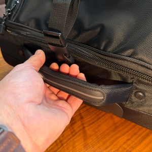 Eine Hand hält den Griff der Amazon Basics Ripstop fest.