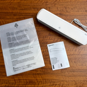 Der Lieferumfang vom Amazon-Basics-Thermo-Laminiergerät liegt auf einem Tisch