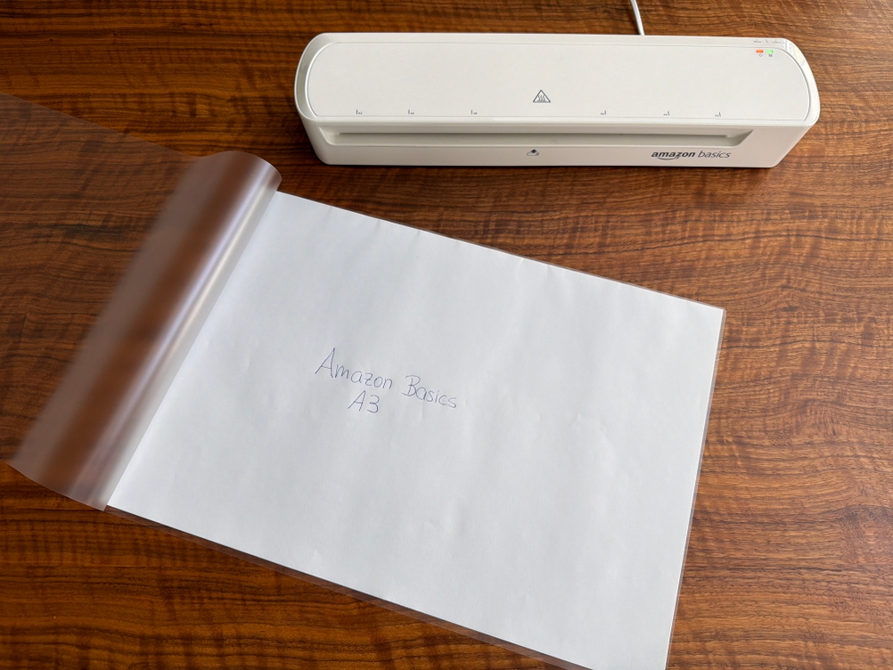 Ein Blatt liegt in einer Folie vom Amazon-Basics-Thermo-Laminiergerät