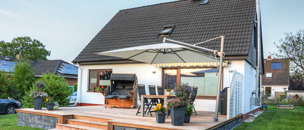 Ein getesteter Ampelschirm steht auf einer Terrasse.